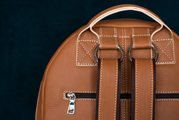 Zaino trasformabile in pelle color cuoio, dettaglio manico, tracolle e zip
