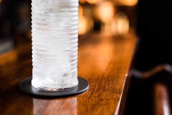 Sottobicchiere in pelle, con bicchiere su bancone in legno