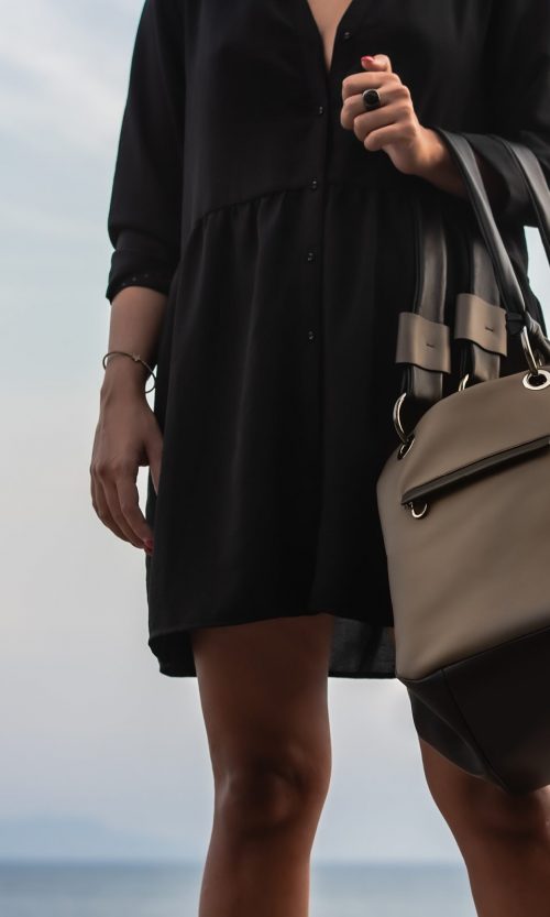 Borsone a spalla Diu, in morbidissima nappa, colore marrone, nero e fango. Foto con sfondo mare. Made in Italy