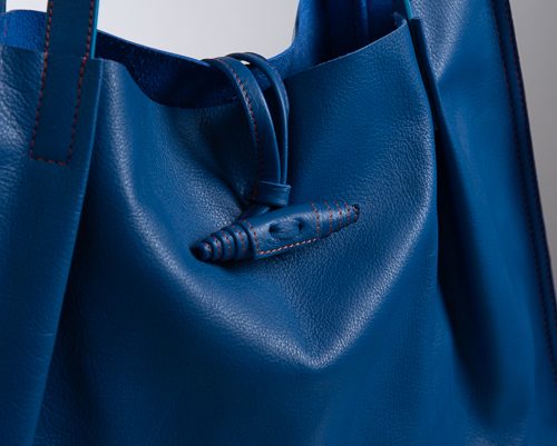 Dettaglio chiusura borsa in pelle di colore blu