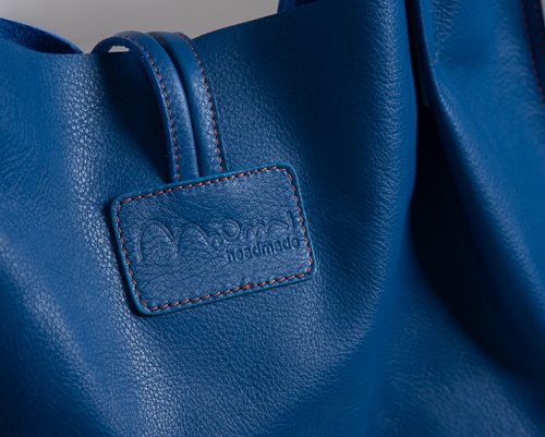 Dettaglio logo borsa in pelle di colore blu